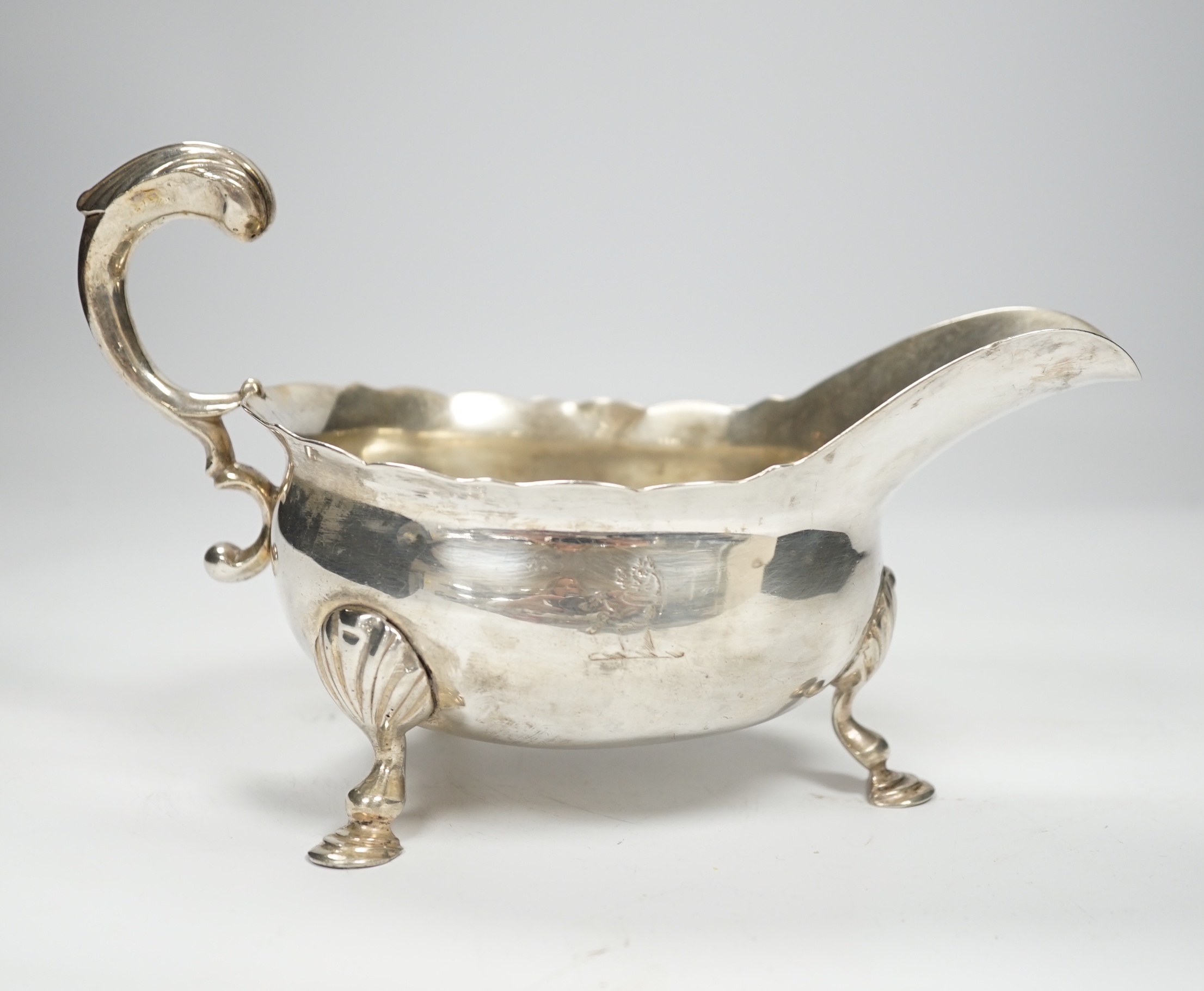 A George II silver sauceboat, with flying scroll handle, John Pollock, London, 1751, length 21cm, 12oz.